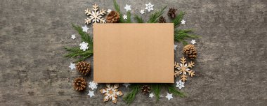 Noel kompozisyonu düzdü. Kare kağıt boş, çam ağacı dalları, renkli arka planda noel süslemeleri. Üst görünüm, metin için boşluk kopyala.