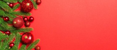 Noel kompozisyonu köknar ağacı, toplar ve renkli arka planda farklı dekorasyonlardan oluşur. Tasarımınız için boş alanı olan Yeni Yıl Advent konseptinin üst görünümü.