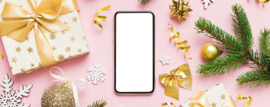 Digital phone mock up with rustic Christmas decorations for app presentation top view with empty space for you design. Christmas online shopping concept. Tablet with copy space on colored background. clipart