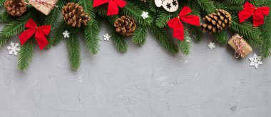 Noel süslemeleri, köknar ağacı dalları ve hediye kutusundaki karanlık masa. Kopyalama alanı olan üst görünüm çerçevesi.