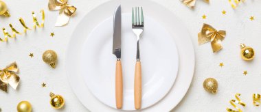 Noel süsleri, tabaklar, inekler, çatallar ve kaşıklarla Noel sofrası. Noel tatili geçmişi. Üst görünüm.