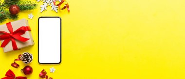 Digital phone mock up with rustic Christmas decorations for app presentation top view with empty space for you design. Christmas online shopping concept. Tablet with copy space on colored background.