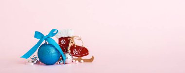 Christmas ball with skates on colored background. decoration bauble with ribbon bow with copy space.