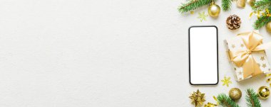 Digital phone mock up with rustic Christmas decorations for app presentation top view with empty space for you design. Christmas online shopping concept. Tablet with copy space on colored background.