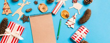 Noel süslemelerinden yapılmış mavi arka plandaki defterin üst görüntüsü. Yeni yıl konsepti.