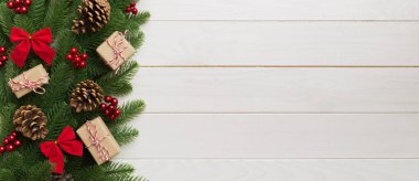 Noel süslemeleri, köknar ağacı dalları ve hediye kutusundaki karanlık masa. Kopyalama alanı olan üst görünüm çerçevesi.