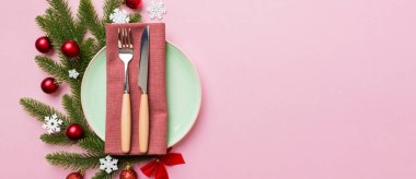 Noel süsleri, tabaklar, inekler, çatallar ve kaşıklarla Noel sofrası. Noel tatili geçmişi. Kopyalama alanı olan üst görünüm.