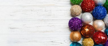 Ahşap arka planda dekoratif takıların şenlikli kompozisyonu. Kopya alanı olan en iyi Noel oyuncakları görünümü.