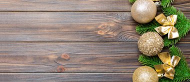 Şenlik baloları, köknar ağacı ve ahşap arka planda Noel süslemeleri. Kopya alanı ile yeni yıl süsü konseptinin en üstü görünümü.