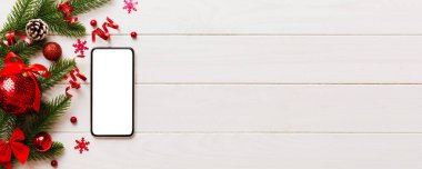 Digital phone mock up with rustic Christmas decorations for app presentation top view with empty space for you design. Christmas online shopping concept. Tablet with copy space on colored background.