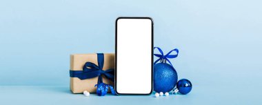 Digital phone mock up with rustic Christmas decorations for app presentation with empty space for you design. Christmas online shopping concept. Tablet with copy space on colored background. clipart