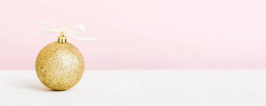 Christmas ball on colored background. decoration bauble with ribbon bow with copy space.