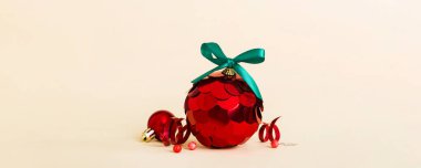 Christmas ball on colored background. decoration bauble with ribbon bow with copy space.