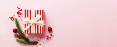 Top view Flat lay Christmas decorations and gift box on colored background with copy space. Christmas or Happy New Year composition.
