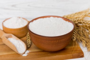 Tahta kasede buğday unu ve renkli arka planda buğday dikenleri. dünya buğday krizi.