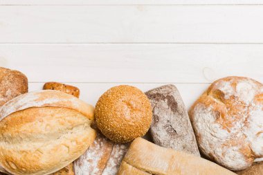 Ev yapımı doğal ekmek. Arka plan olarak farklı taze ekmek türleri, kopya alanı ile üst görünüm.