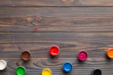 Renkli arka planda farklı renkte gagalı kavanozlar. Hobi resim. Boşluğu olan üst görünüm. Yaratıcılık için işyeri. ev öğretmenliği kavramı çizimi.