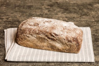 Kırsal masa manzaralı peçeteli taze pişmiş ekmek çeşitleri. Sağlıklı mayasız ekmek. Fransız ekmeği.