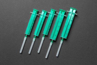 Renkli arka planda fotokopi alanı olan tıbbi şırıngaların üst görüntüsü. Enjeksiyon ekipmanı konsepti.