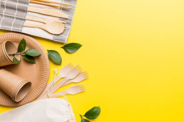 Açık beyaz masa arkaplanındaki boş, tek kullanımlık çevre dostu tabaklar, bardaklar, çatal bıçaklar. Üst Manzara. Biyo-çözünebilir el yapımı yemekler. Geri dönüşüm konsepti. Yakın plan..