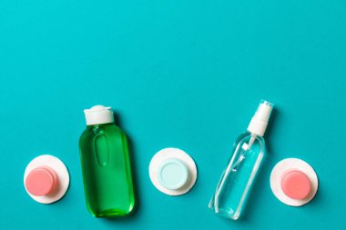 Renkli arka planda seyahat etmek için bir grup küçük şişe. Fikirlerin için uzayı kopyala. Kozmetik ürünlerin düz bileşimi. Pamuklu krema kaplarının üst görüntüsü.