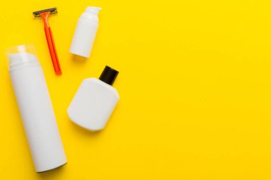 Tıraş Adam seti. Traş makinesi, havlu, losyon ve renkli arka planda tıraş köpüğü. Erkekler banyo aksesuarları üst görünüm.