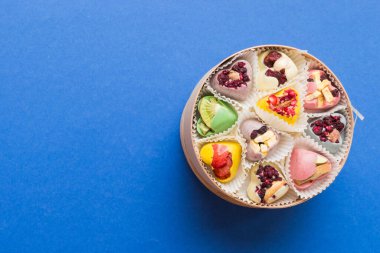 Holiday composition: sweet candy, with gift boxes with bow and chocolate hearts, photo template, background. Top View with copy space on colored background.