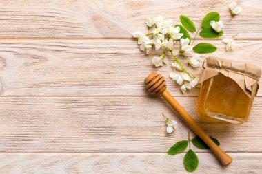 Akasya çiçekli ve yapraklı bal kavanozu. Taze bal üst görünüm düz yatıyordu.