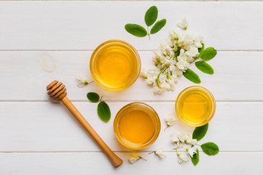 Akasya çiçekli ve yapraklı bal kavanozu. Taze bal üst görünüm düz yatıyordu.