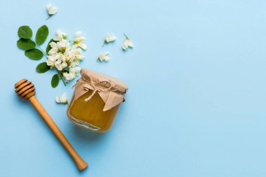 Akasya çiçekli ve yapraklı bal kavanozu. Taze bal üst görünüm düz yatıyordu.