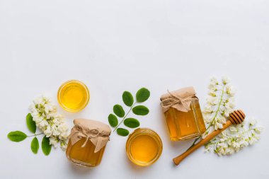 Akasya çiçekli ve yapraklı bal kavanozu. Taze bal üst görünüm düz yatıyordu.