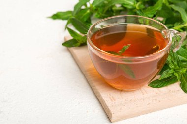 Arka planda bir fincan nane çayı. Fotokopi alanı ile taze nane görünümlü yeşil çay.