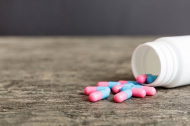 plastic medicine bottle with capsules of pills on colored background. Online pharmacy. Painkiller medicine and antibiotic drug resistance concept. Pharmaceutical industry.