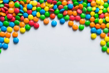 Renkli arka planda karışık renkli şeker koleksiyonu. Düz yerde, üst tarafta. Renkli çikolata kaplı şeker çerçevesi.