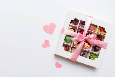 Valentine day composition: sweet candy, with gift boxes with bow and red felt hearts, photo template, background. Top View with copy space.