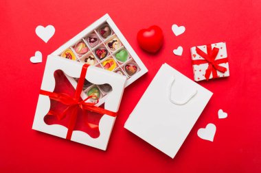 Valentine day composition: sweet candy, with gift boxes with bow and red felt hearts, photo template, background. Top View with copy space.