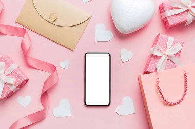 mobile phone with blank screen on colored background with hearts, valentine day concept top view flat lay.