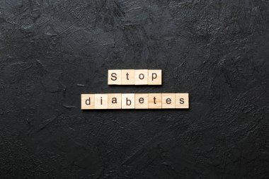 Ağaç bloğunda yazan şeker hastalığını durdur. Top view konseptiniz için beton masadaki diyabet metnini durdurun.