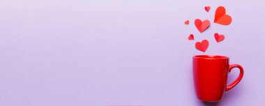 Renkli arka planda kırmızı bardak, kırmızı küçük kalpler, kopya alanı ile üst görünüm.