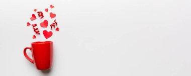 Renkli arka planda kırmızı bardak, kırmızı küçük kalpler, kopya alanı ile üst görünüm.