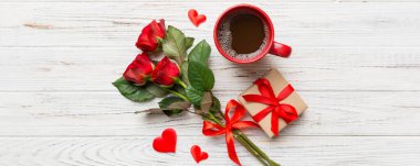 Kahve fincanı, gül çiçeği ve hediye kutusuyla Sevgililer Günü kompozisyonu. Üst manzara, düz yatış. Tatil kavramı.