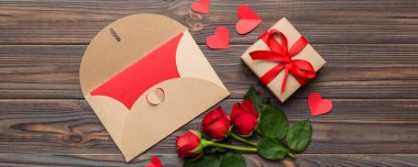 Zarflı sevgililer günü kompozisyonu, gül çiçeği ve kırmızı kalp masada. Üst görünüm, düz görünüm, kopyalama alanı Tatil kavramı.