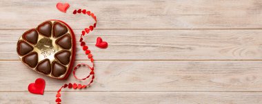 Sevgililer Günü için kırmızı kutuda lezzetli çikolatalı pralinler. Kalp şeklinde çikolata kutusu, fotokopi alanı ile üst görünüm..