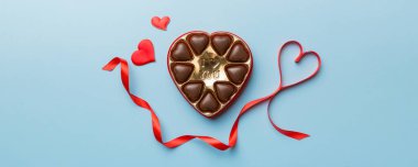 Sevgililer Günü için kırmızı kutuda lezzetli çikolatalı pralinler. Kalp şeklinde çikolata kutusu, fotokopi alanı ile üst görünüm..