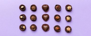 Renkli masa üzerinde farklı çikolata çeşitleri var. Üst Görünüm ve Düz Yatay.