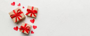 Sevgililer Günü kompozisyonu: Yay ve kalple kırmızı hediye kutusu. Noel hediyesi. Yukarıdan bak. Mesaj için yer var. Holday tebrik kartı.