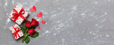 Gül çiçeği, kırmızı kalp ve hediye kutularıyla Sevgililer Günü kompozisyonu. Anneler günü ve doğum günü tebriği, kopyalama alanı, üst görünüm.