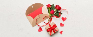 Zarflı sevgililer günü kompozisyonu, gül çiçeği ve kırmızı kalp masada. Üst görünüm, düz görünüm, kopyalama alanı Tatil kavramı.