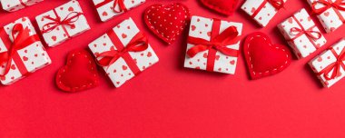 Hediye kutularının ve renkli arka planda kırmızı tekstil kalplerinin üst görüntüsü. Kopya alanı ile Sevgililer Günü konsepti.