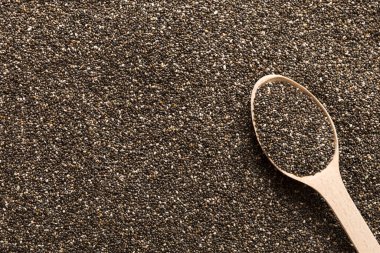 Space for text Texture of chia seeds with wooden spoon, superfood concept. Top view.